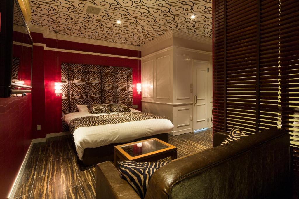 une chambre avec un lit et un canapé dans l'établissement Hotel Youme Tsukasa (Love Hotel), à Yame