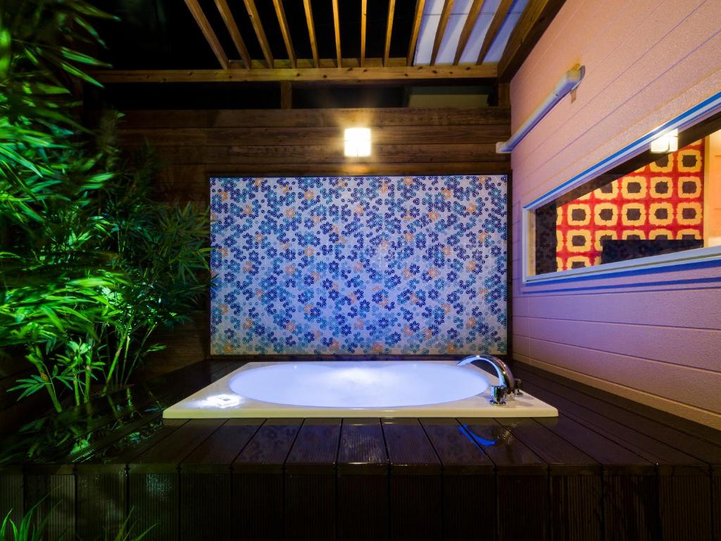 une salle de bain avec une baignoire à motif bleu dans l'établissement Hotel Tosu Tsukasa (Love Hotel), à Tosu