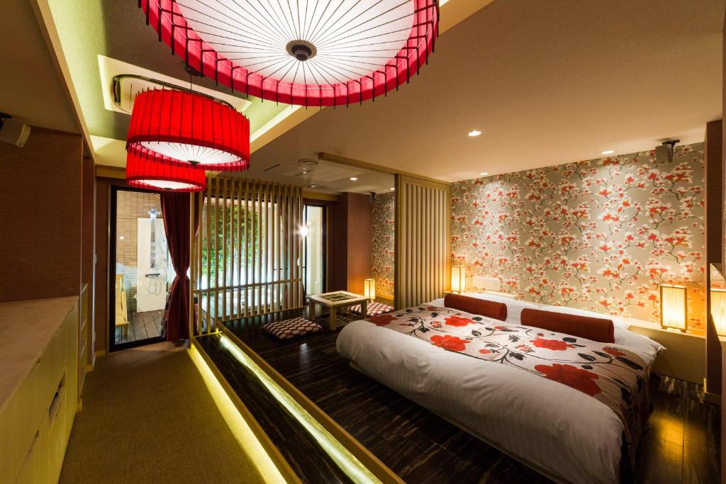 une chambre avec un lit et un lustre dans l'établissement Hotel CLover Leaf Tsukasa (Love Hotel), à Tosu