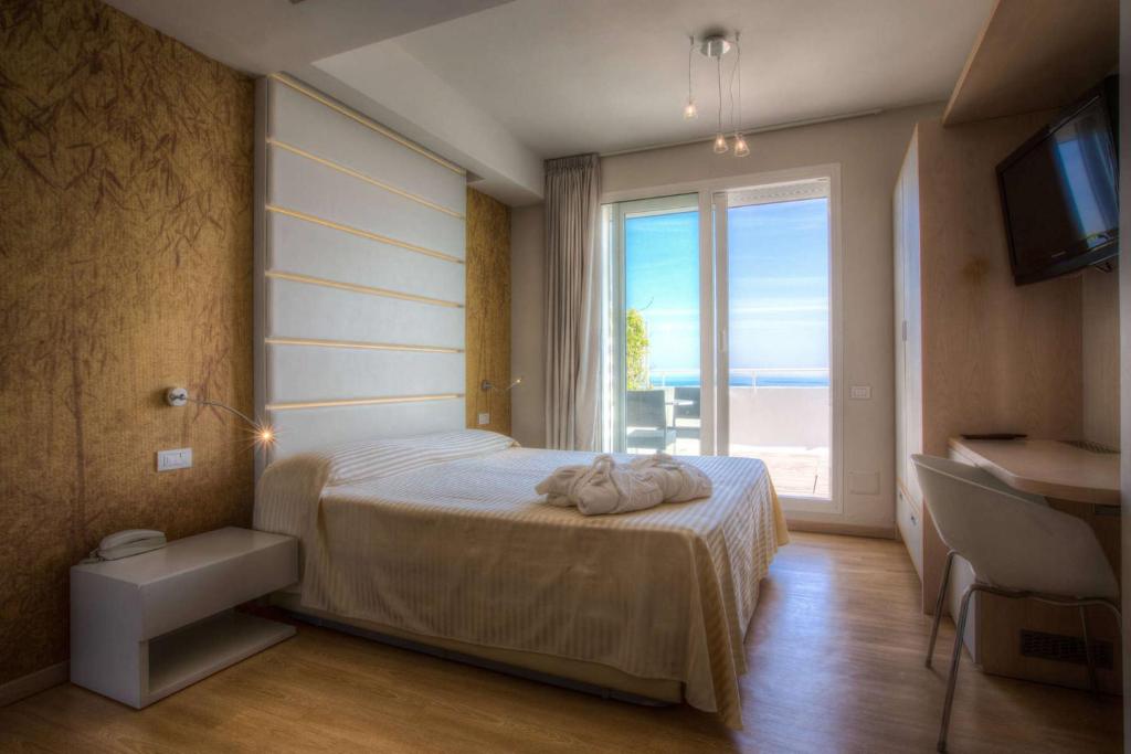une chambre avec un lit et une grande fenêtre dans l'établissement Hotel Commodore, à Riccione