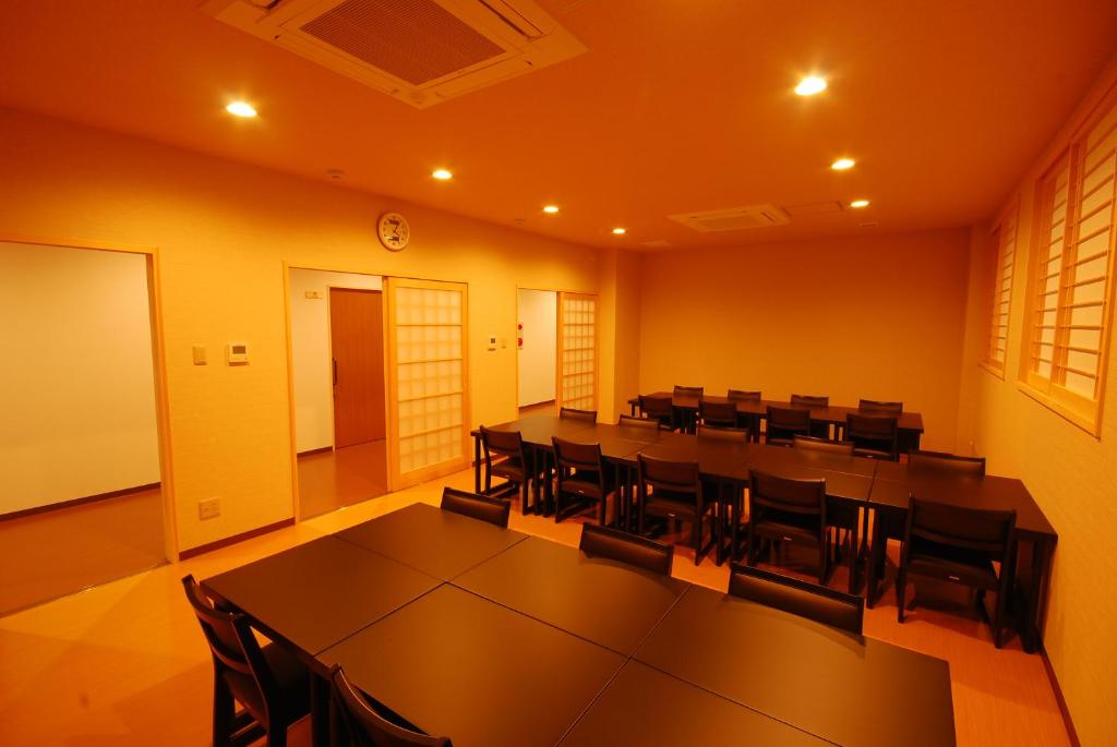 une salle de conférence avec une longue table et des chaises dans l'établissement 高野山 宿坊 増福院 -Koyasan Shukubo Zofukuin-, à Koyasan