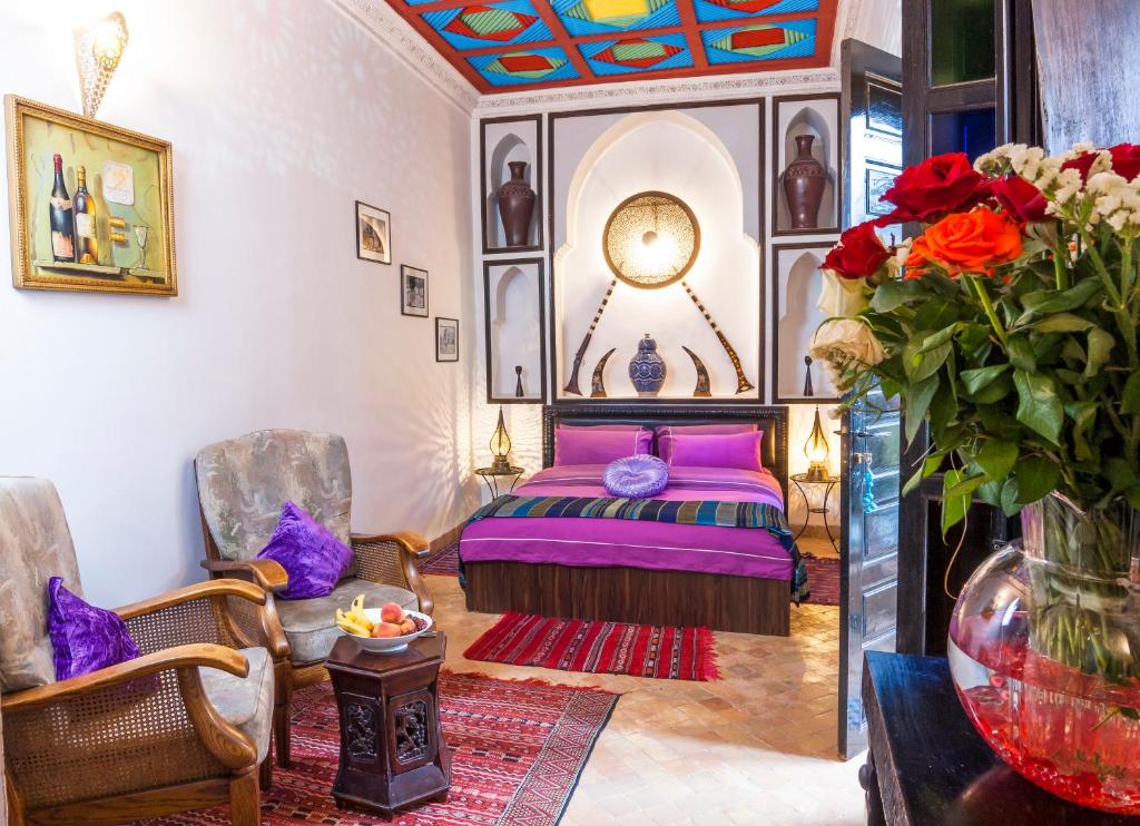 - une chambre avec un lit et un vase de fleurs dans l'établissement Riad Tamarrakecht, à Marrakech