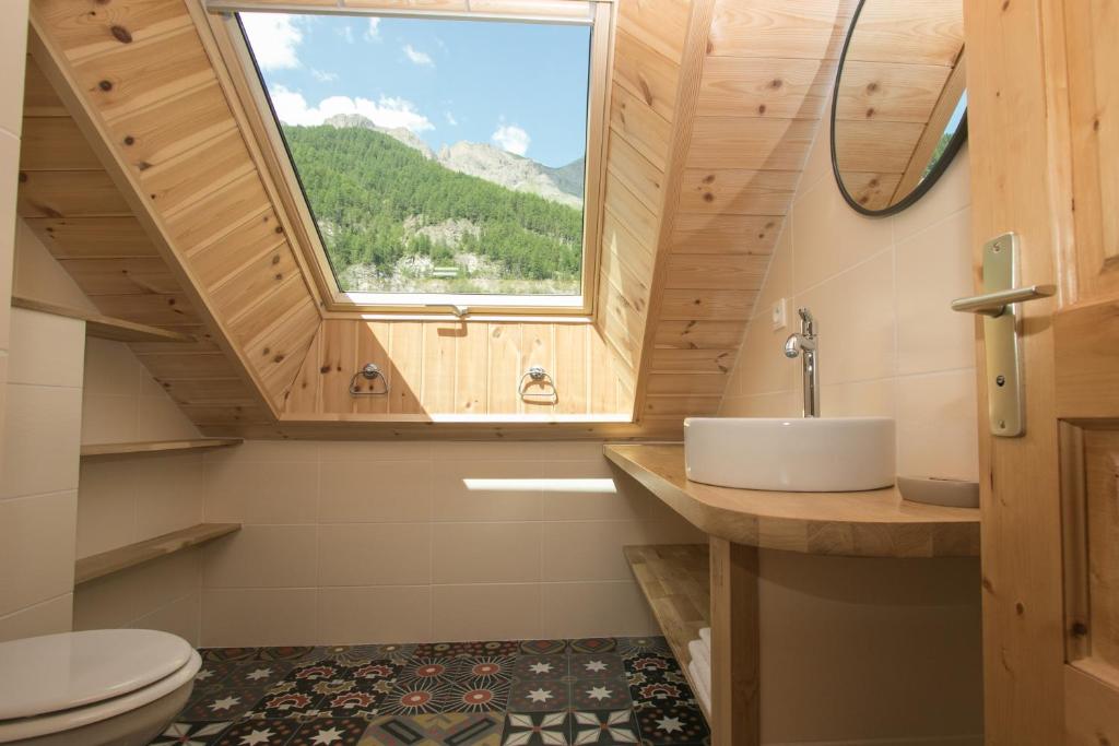 une salle de bain avec un lavabo et une fenêtre dans l'établissement La Baïta Du Loup, à Saint-Véran