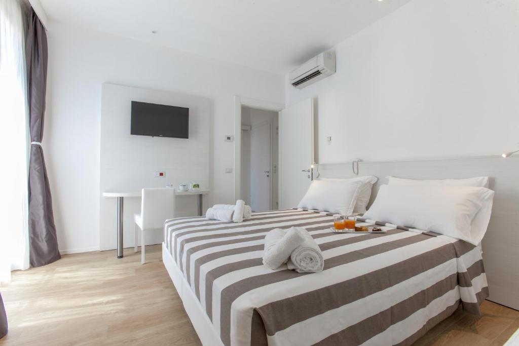 une chambre avec un grand lit avec des serviettes dessus dans l'établissement Hotel Houston Suites, à Rimini