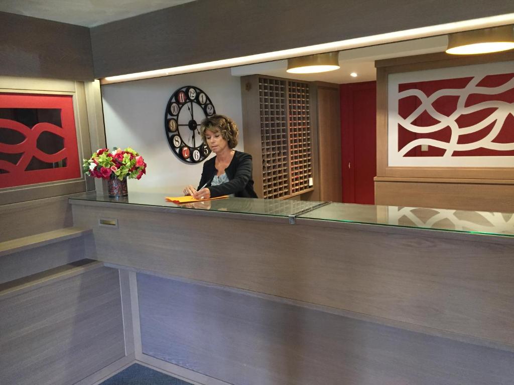 une femme debout au comptoir dans le hall de l'hôtel dans l'établissement Résidence Le Chamois d'Or, à Val Thorens