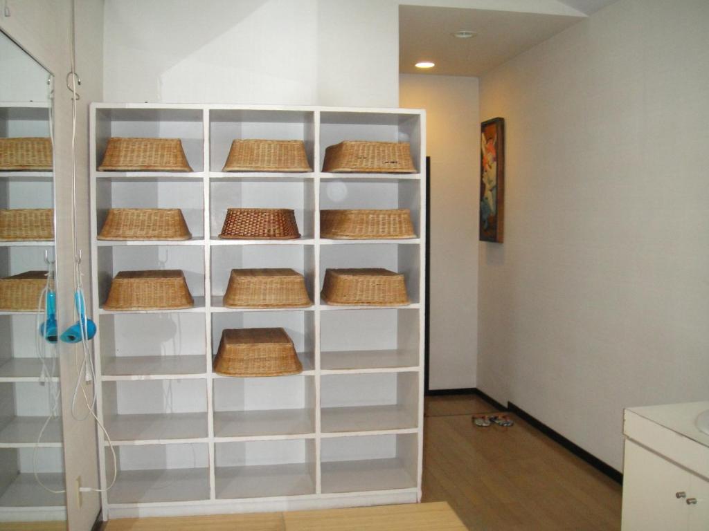 une étagère blanche avec des paniers dessus dans une cuisine dans l'établissement Ryokan Kamomeso, à Sado 37 autres photos