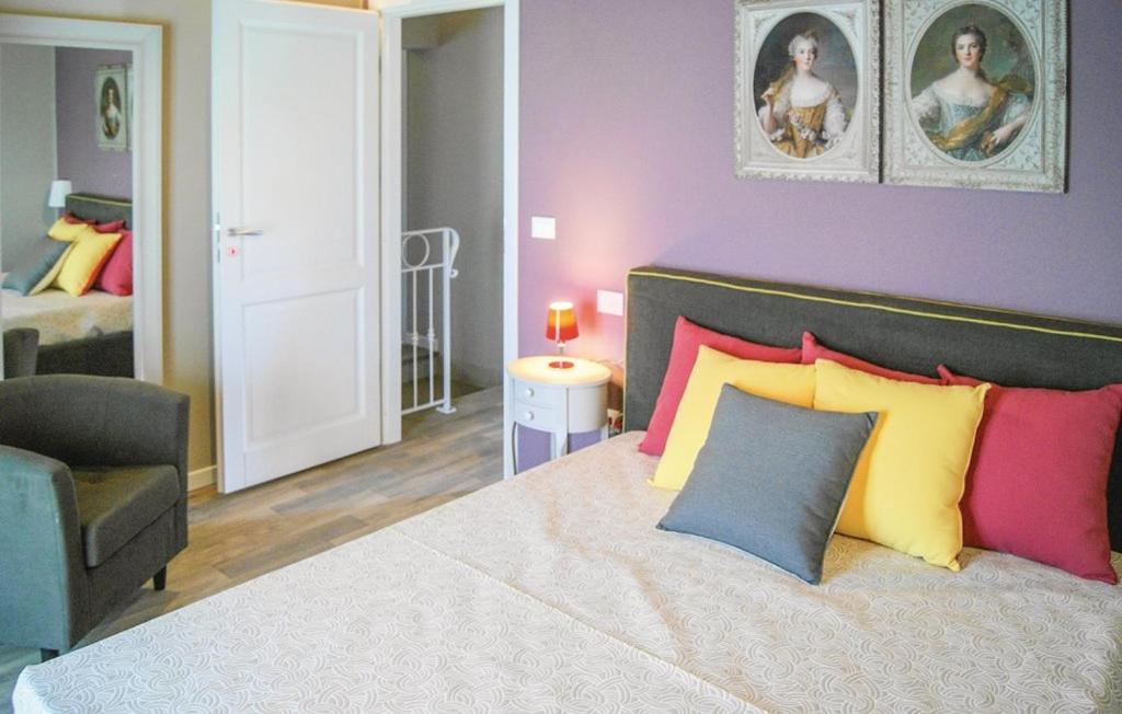 une chambre avec un grand lit avec des oreillers colorés dans l'établissement Villa Marina with private panoramic pool - Borgo del Silenzio, à Orciatico 14 autres photos