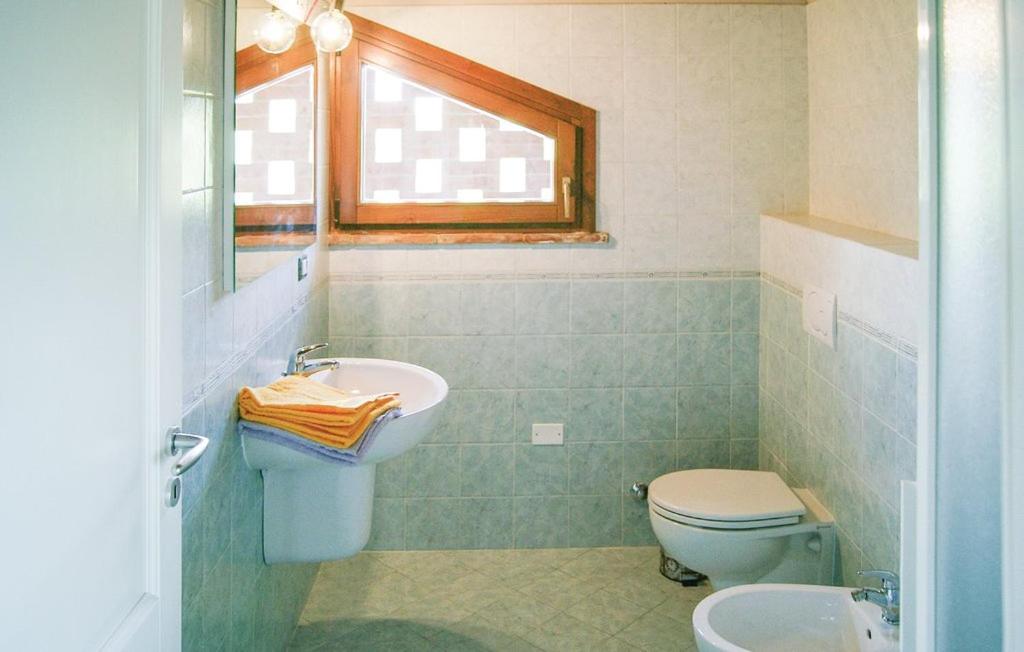 une salle de bain avec un lavabo et des toilettes et une fenêtre dans l'établissement Villa Marina with private panoramic pool - Borgo del Silenzio, à Orciatico
