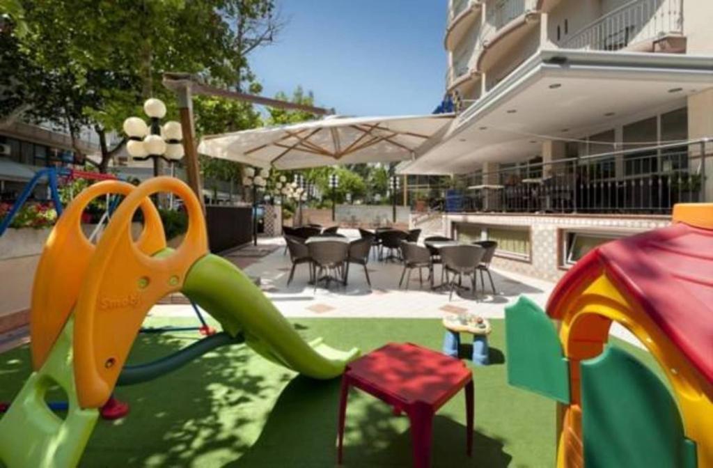 une aire de jeux pour enfants avec un toboggan et des équipements de jeux dans l'établissement Hotel Ambra, à Rimini