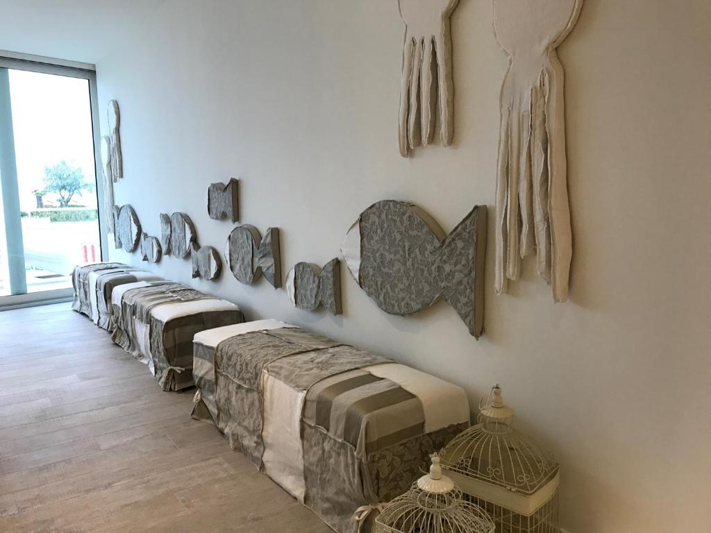 une chambre avec une rangée de tables sur un mur dans l'établissement Stellamare, à Caorle