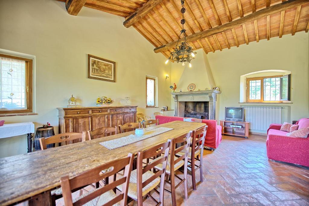 - un salon avec une grande table et des chaises en bois dans l'établissement Villa Poggio Conca by PosarelliVillas, à Incisa in Valdarno