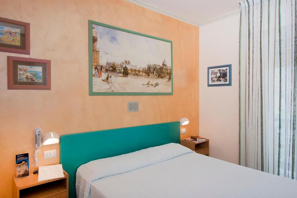 une chambre avec un lit et un tableau au mur dans l'établissement Hotel Marselli, à Rimini