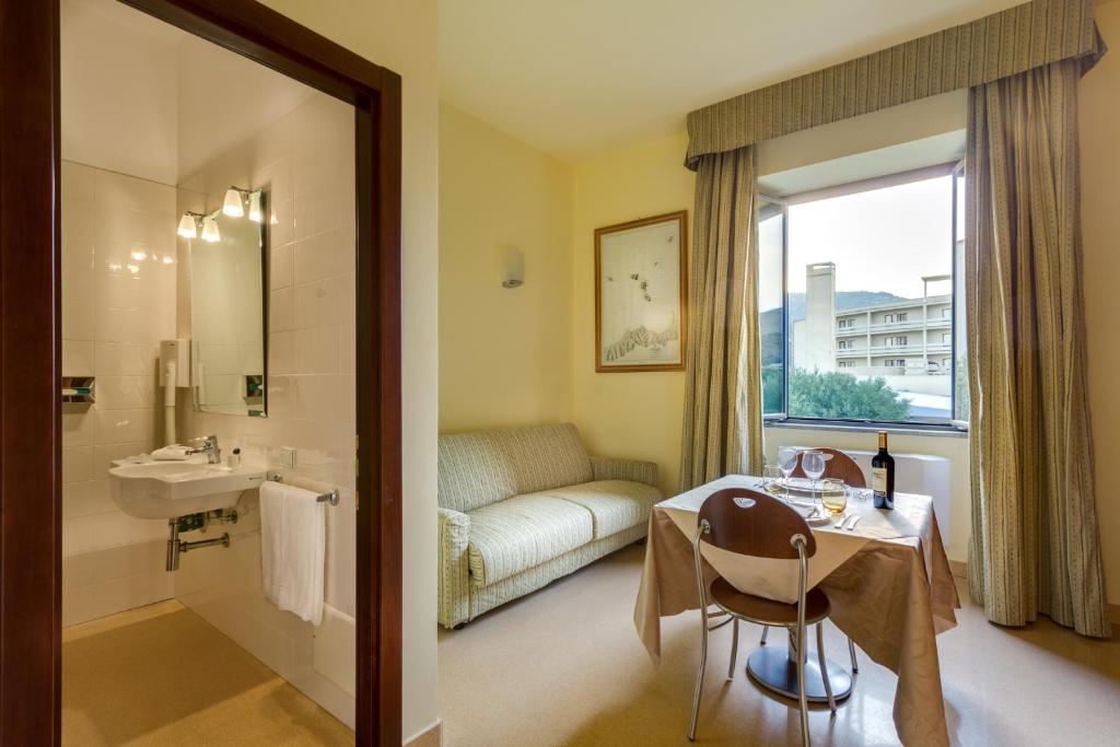 La salle de bains est pourvue d'un lavabo, d'une douche et d'une table. dans l'établissement Rada Siri, à Montepaone