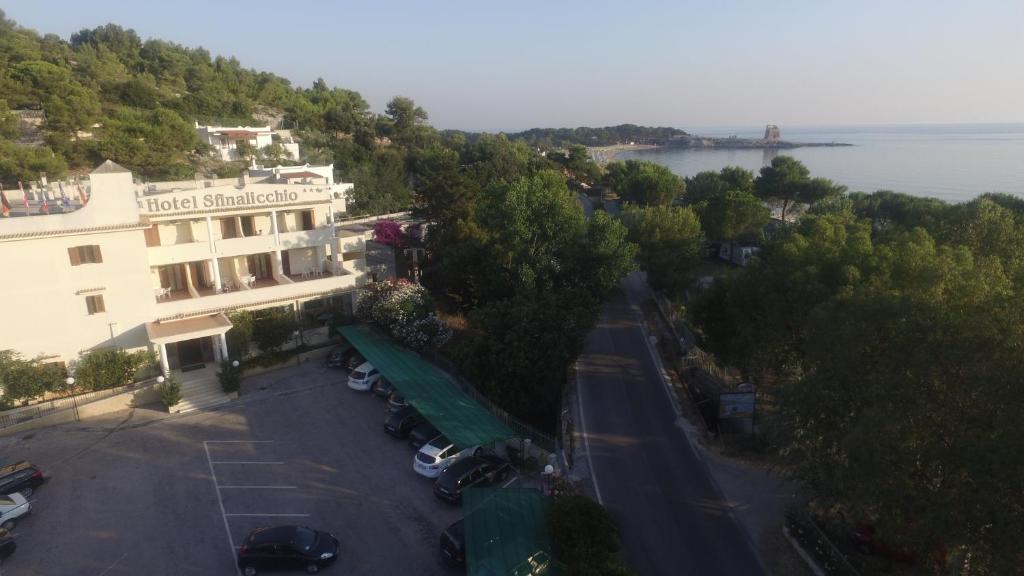 Vue aride d'un hôtel avec des voitures garées dans un parking dans l'établissement Hotel Sfinalicchio, à Vieste