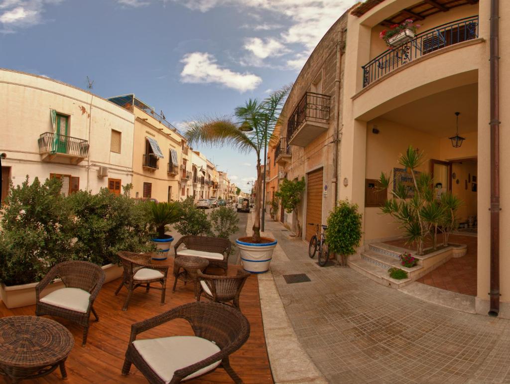 une terrasse avec des chaises et des tables dans une rue. dans l'établissement Al-Tair, à San Vito Lo Capo