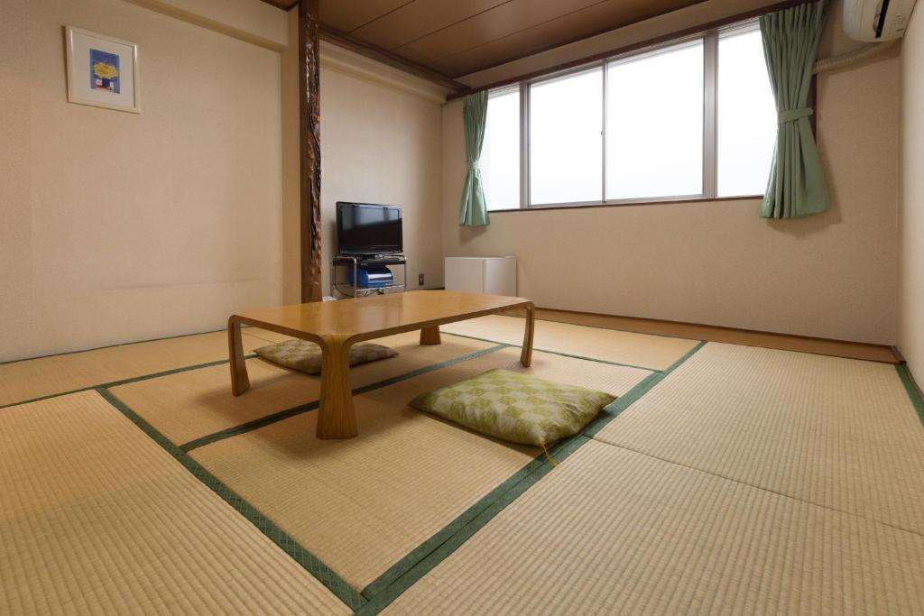 un salon avec une table et une grande fenêtre dans l'établissement Suimeiso, à Oshu
