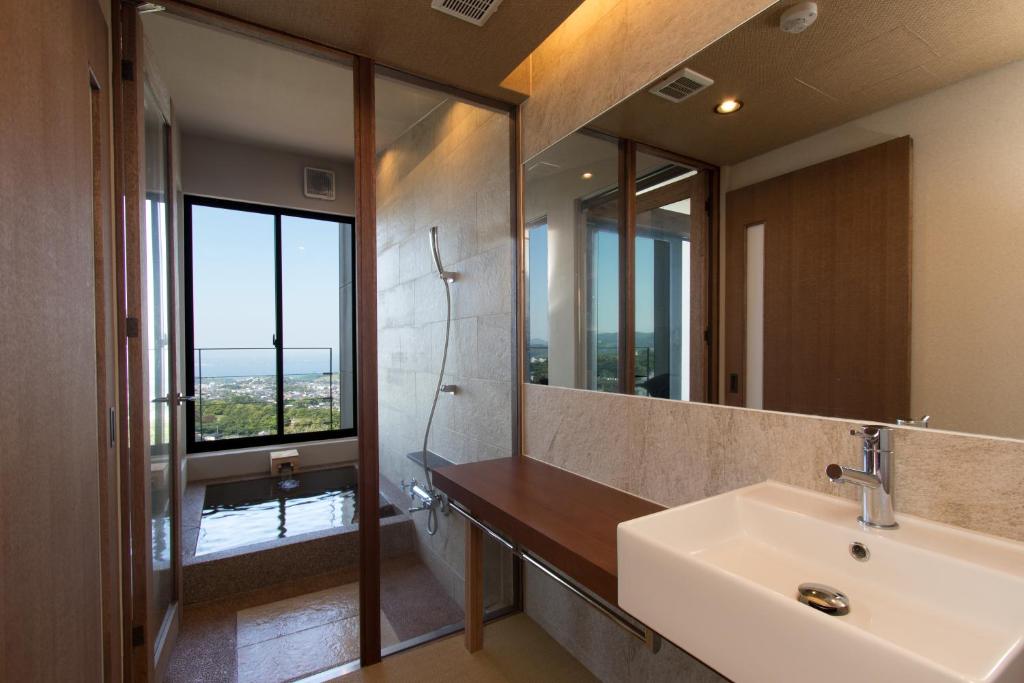 une salle de bain avec un lavabo et un grand miroir dans l'établissement SEKIYA RESORT Terrace Midoubaru, à Beppu