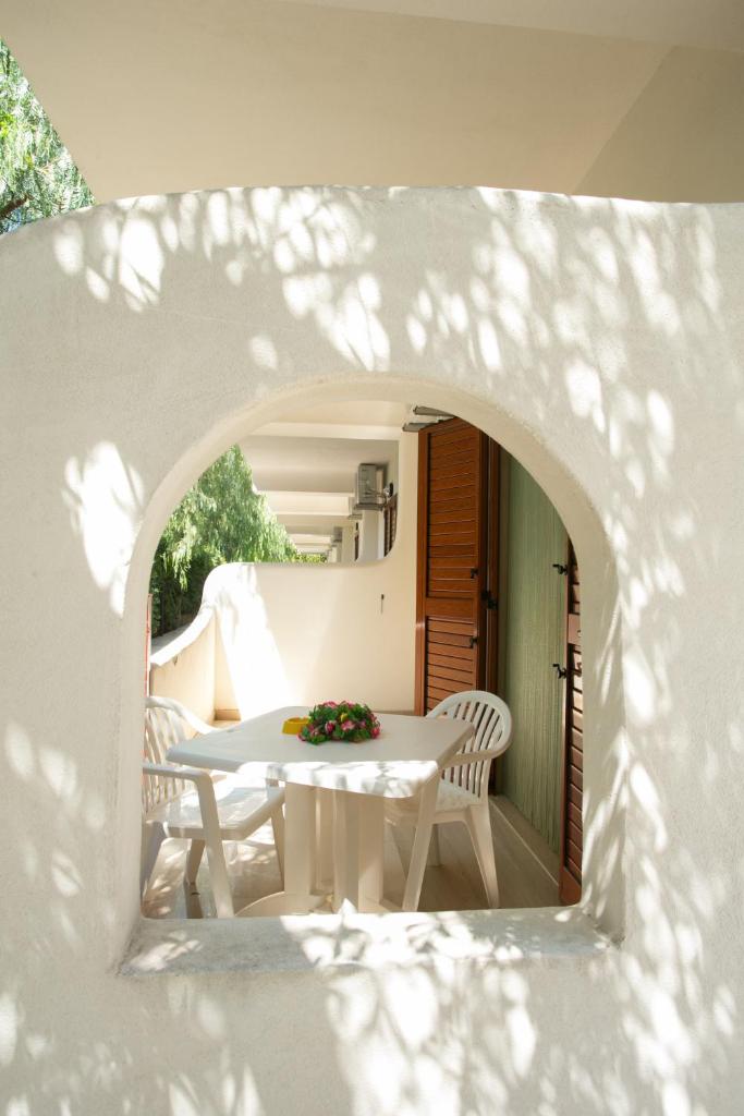 une table blanche avec des chaises blanches et une table avec des fleurs dans l'établissement Residence Adriatico, à Mattinata