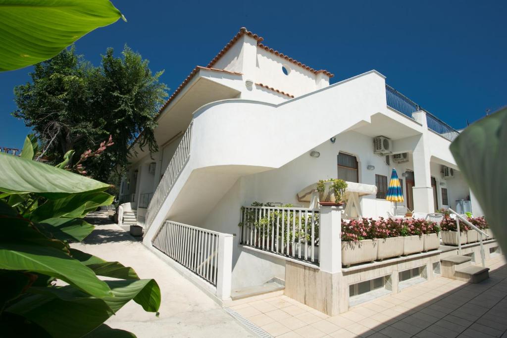 Cette maison blanche dispose d'un balcon. dans l'établissement Residence Adriatico, à Mattinata
