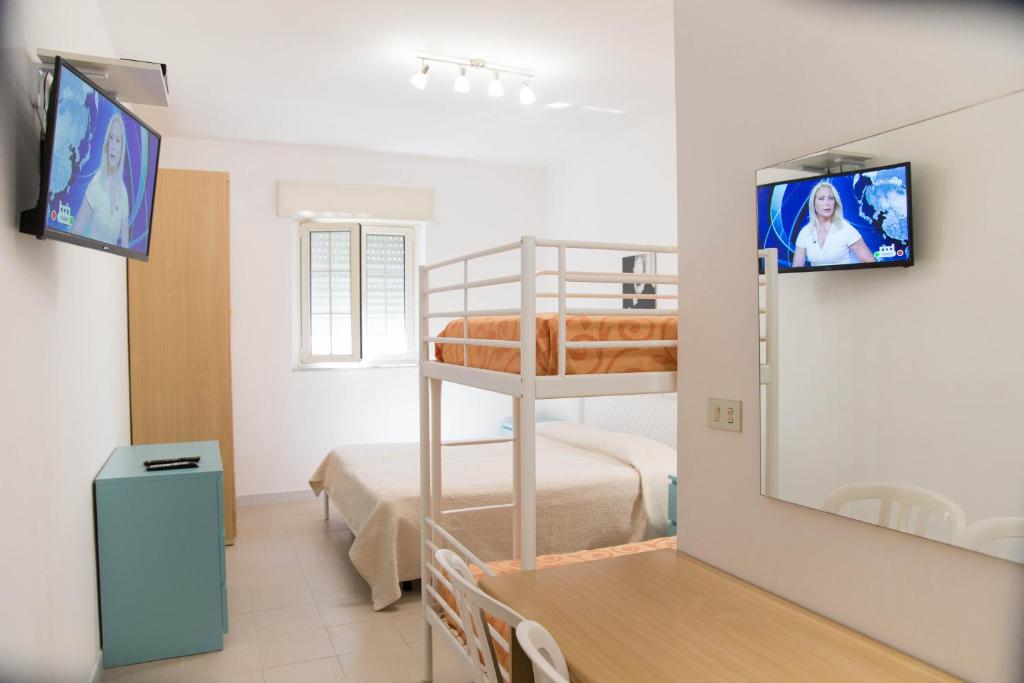 une petite chambre avec des lits superposés et une chambre dans l'établissement Residence Adriatico, à Mattinata