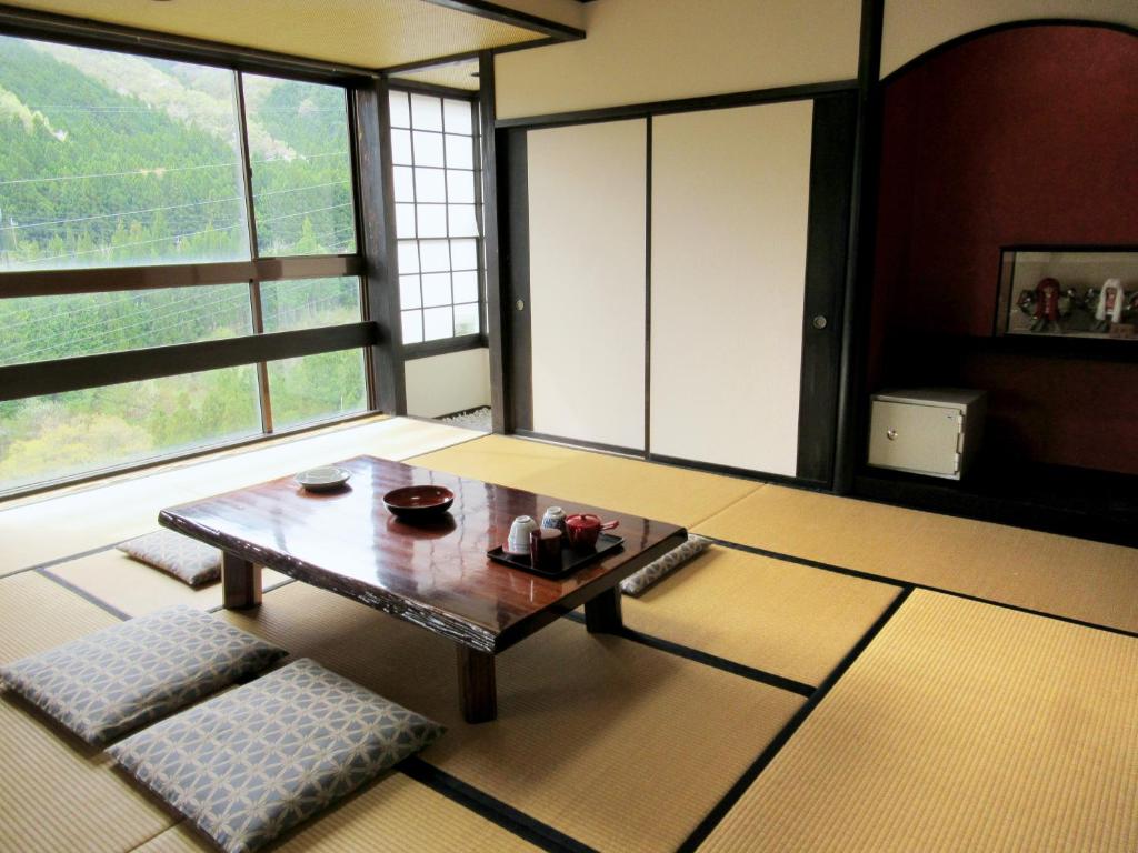 - un salon avec une table basse et de grandes fenêtres dans l'établissement Hotel Manyotei, à Nikkō 34 autres photos
