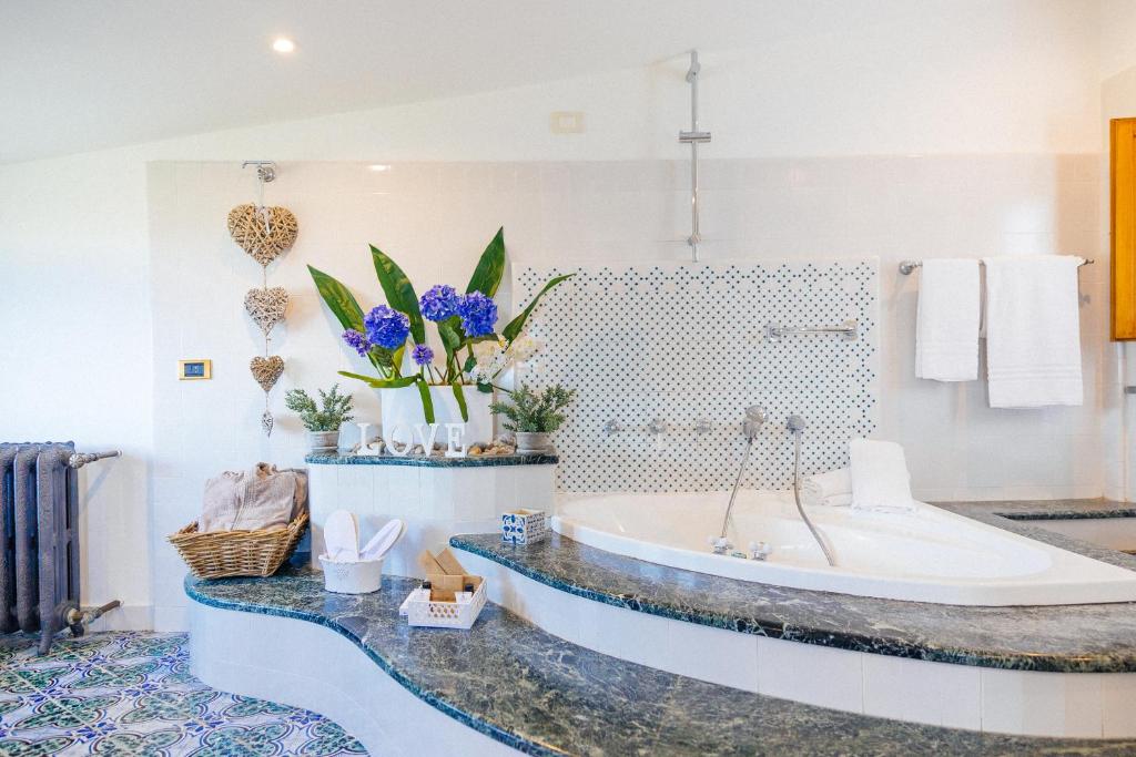 La salle de bains est pourvue d'une baignoire et de fleurs. dans l'établissement Villa Carolina Sorrento Private Heated Pool and Sea View, à Sorrente