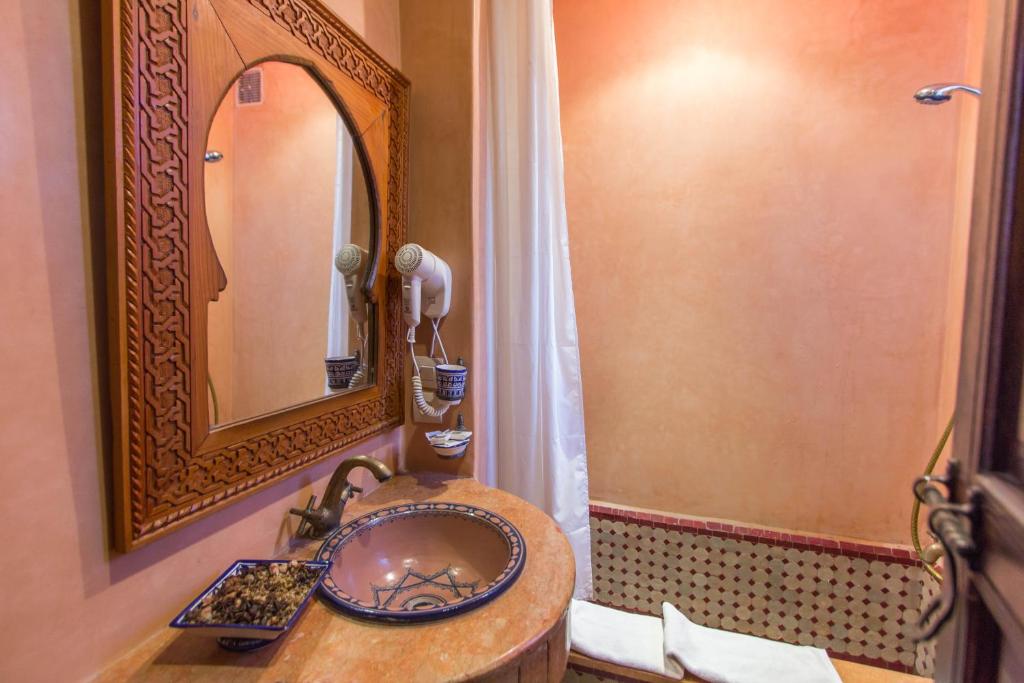 une salle de bain avec un lavabo et un miroir dans l'établissement Dar Fes Medina Ziat, à Fès 37 autres photos