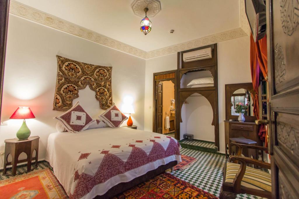 une chambre avec un lit et un miroir dans l'établissement Dar Fes Medina Ziat, à Fès