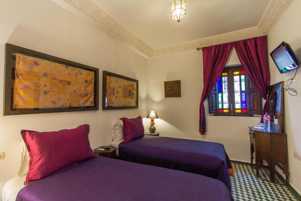 une chambre d'hôtel avec deux lits et une télévision dans l'établissement Dar Fes Medina Ziat, à Fès