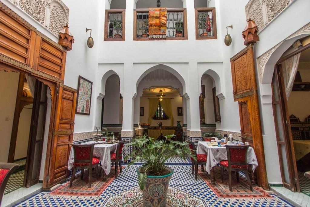 un restaurant avec des tables et des chaises dans un bâtiment dans l'établissement Dar Fes Medina Ziat, à Fès
