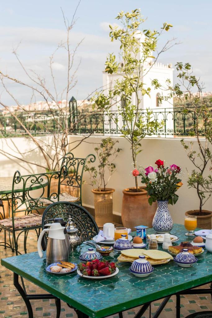 une table verte avec des assiettes de nourriture dans l'établissement Dar Fes Medina Ziat, à Fès