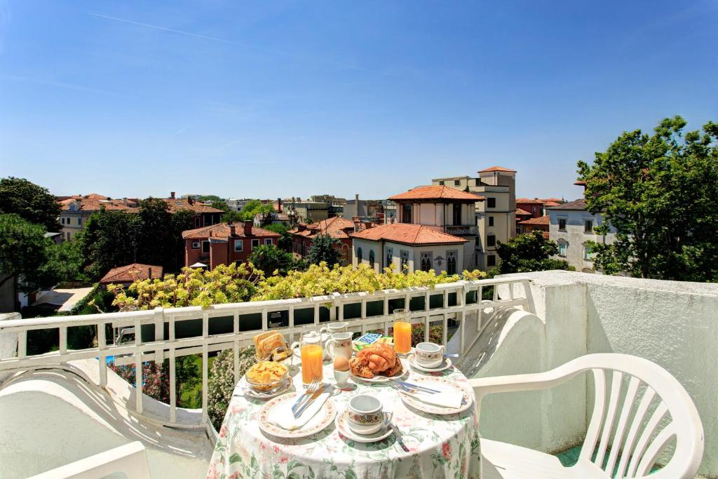 - une table avec de la nourriture et des boissons sur le balcon dans l'établissement Hotel Biasutti, sur le Lido de Venise