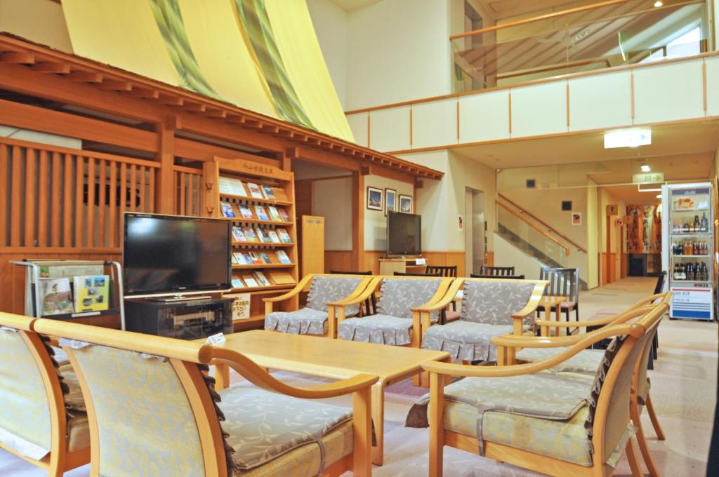 une bibliothèque avec des chaises, une table et une télévision dans l'établissement Kobushi no Yu Atsuma, à Atsuma