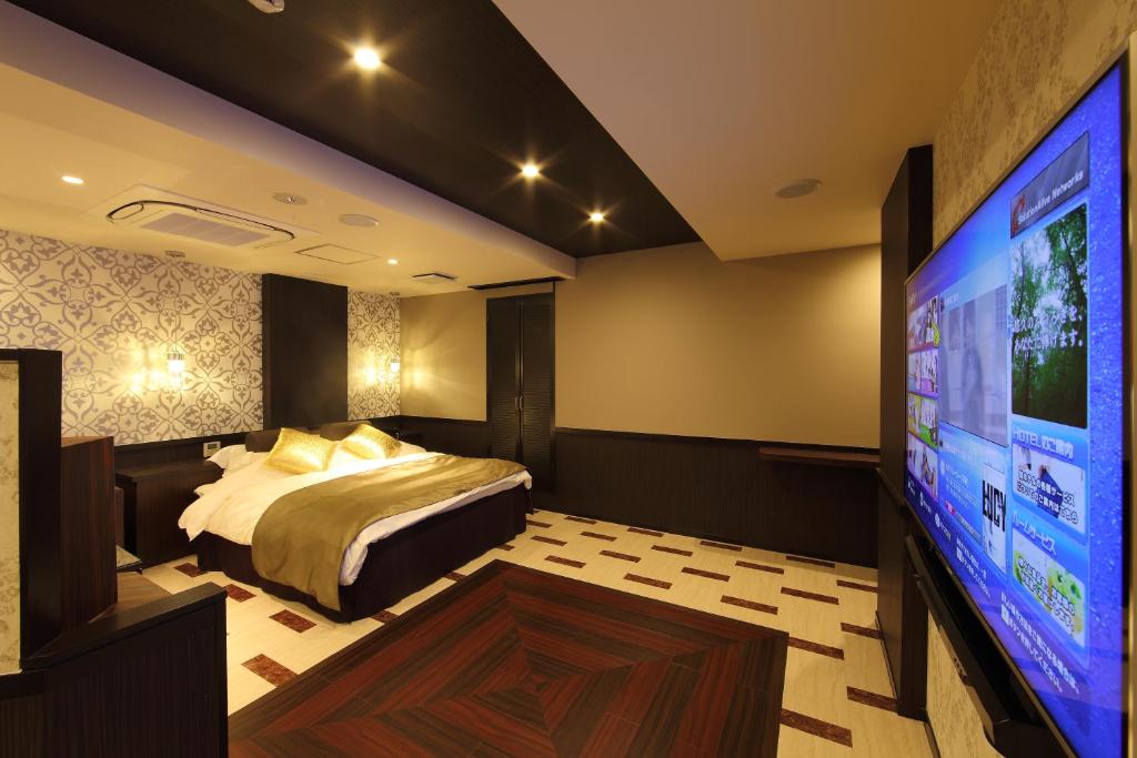 une chambre avec un lit et une télévision à écran plat dans l'établissement Hotel Water Gate Hamamatsu (Adult Only), à Hamamatsu