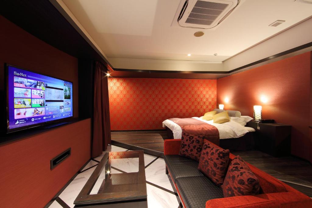 une chambre d'hôtel avec un lit et une télévision à écran plat dans l'établissement Hotel Water Gate Hamamatsu (Adult Only), à Hamamatsu 2 autres photos