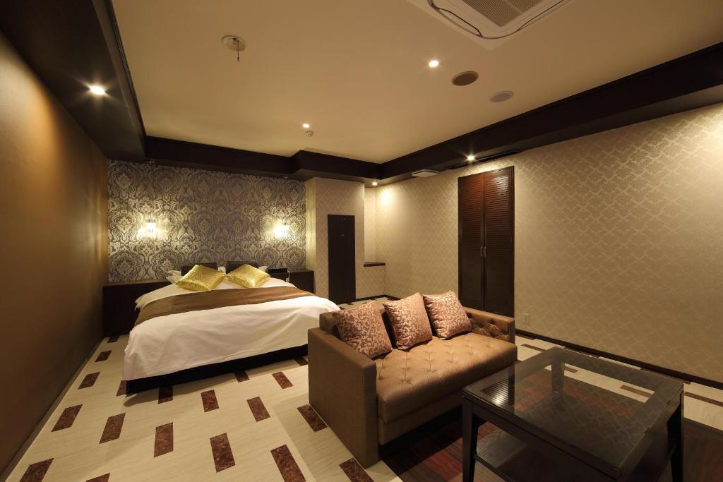 une chambre avec un lit, un canapé et une table dans l'établissement Hotel Water Gate Hamamatsu (Adult Only), à Hamamatsu