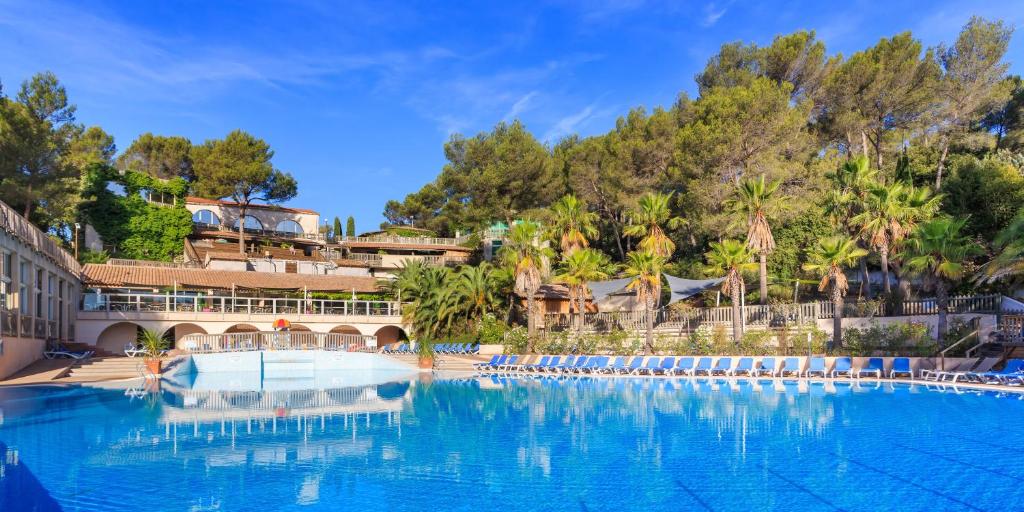 une grande piscine avec des chaises et des arbres dans l'établissement Frantheor Fréjus 5 étoiles, à Fréjus 37 autres photos