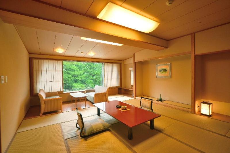 un salon avec une table et un canapé dans l'établissement Hotel New Mitoya, à Sendai