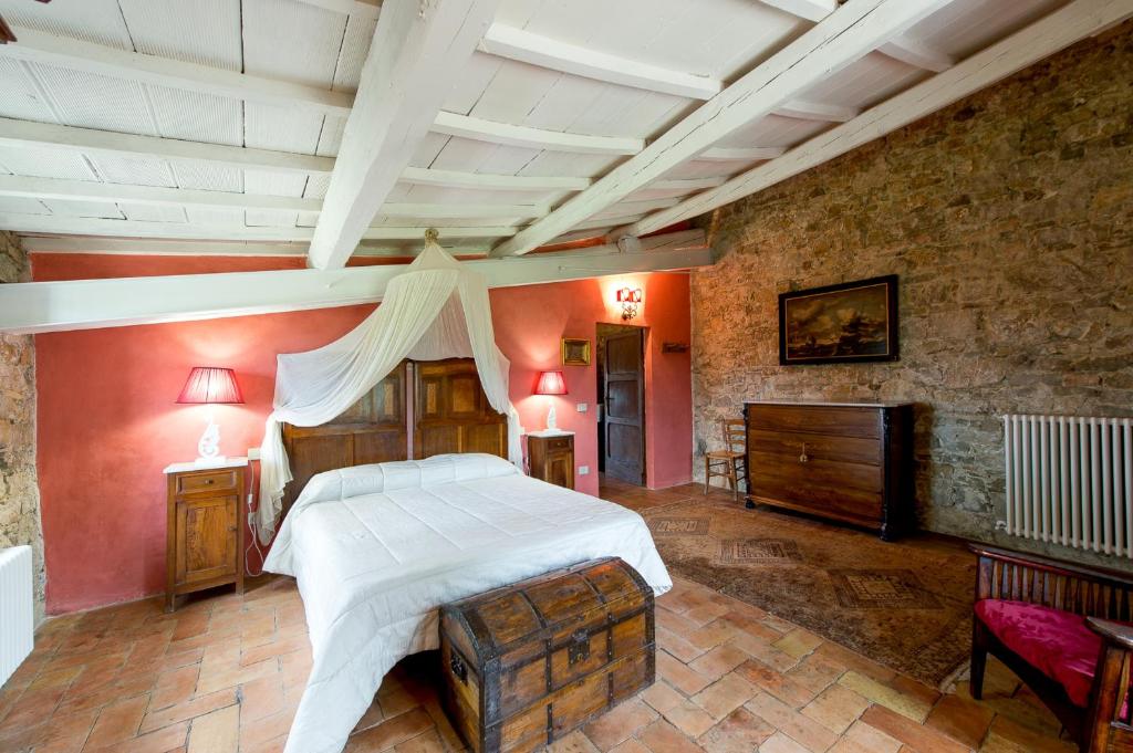 une chambre avec un grand lit et un mur en pierre dans l'établissement Il Granaio, à San Venanzo 41 autres photos