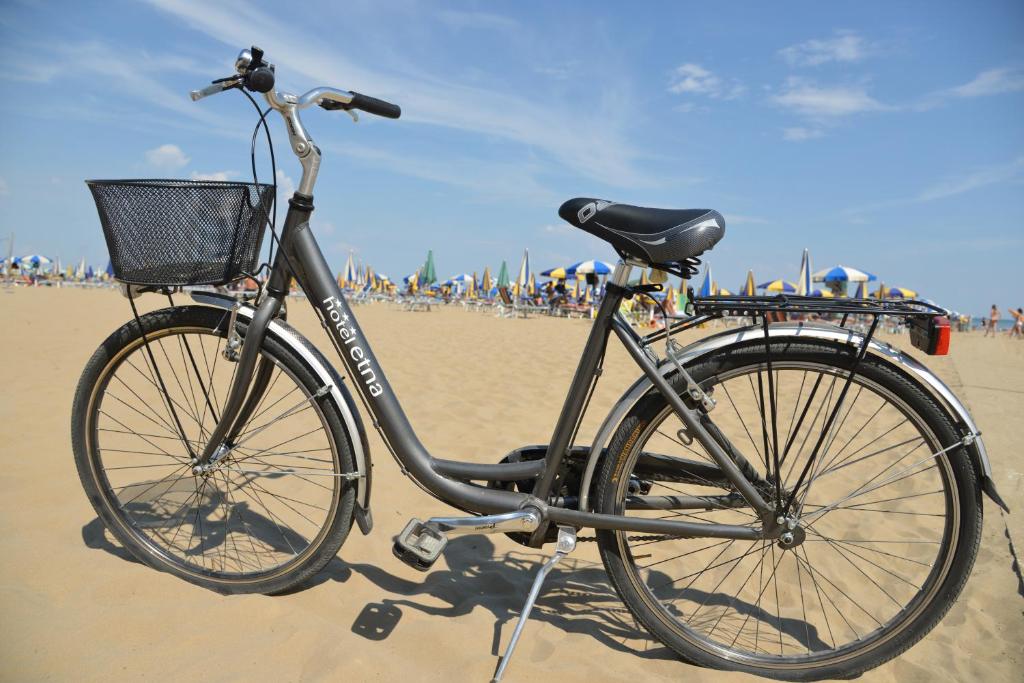 un vélo garé sur la plage près de la plage dans l'établissement Hotel Etna, à Lignano Sabbiadoro