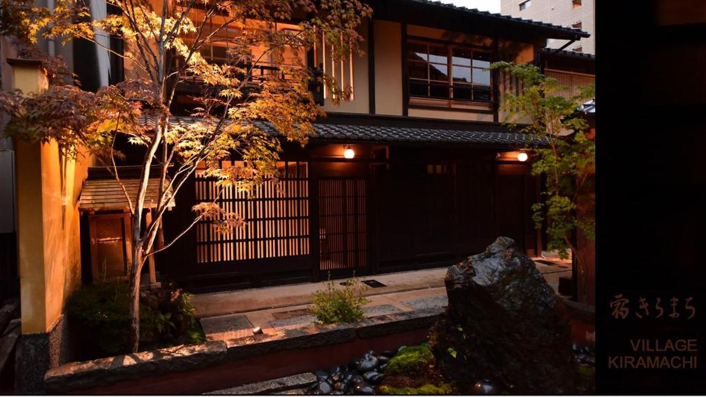 une maison avec une porte et un arbre en face de celle-ci dans l'établissement Yado Kiramachi, à Kyoto