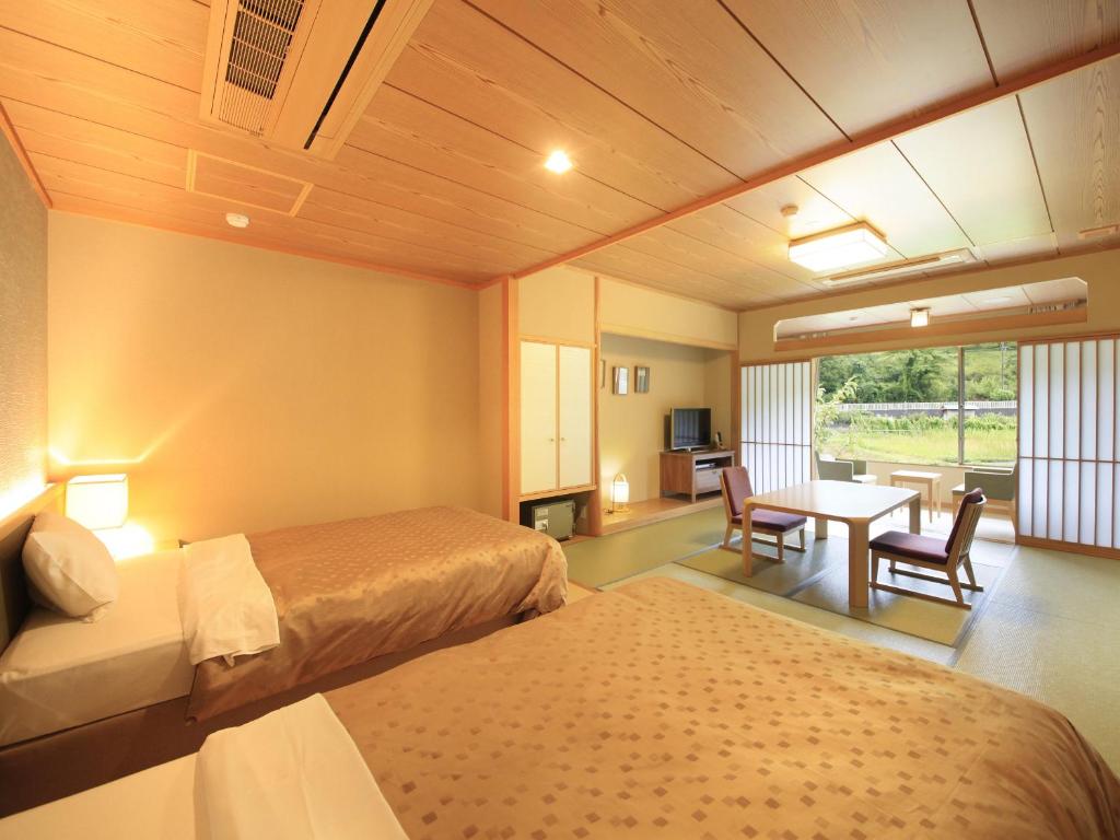 une chambre d'hôtel avec deux lits et une table dans l'établissement Shimoda Central Hotel, à Shimoda