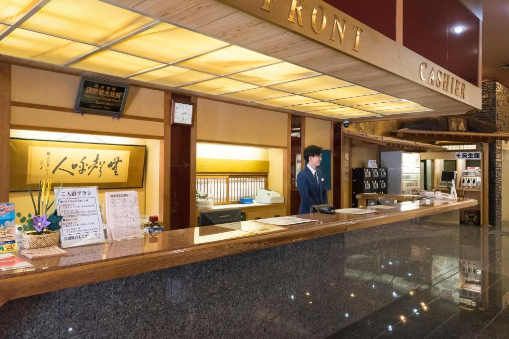 un homme debout à un comptoir dans un magasin dans l'établissement Awara Grand Hotel, à Awara 37 autres photos