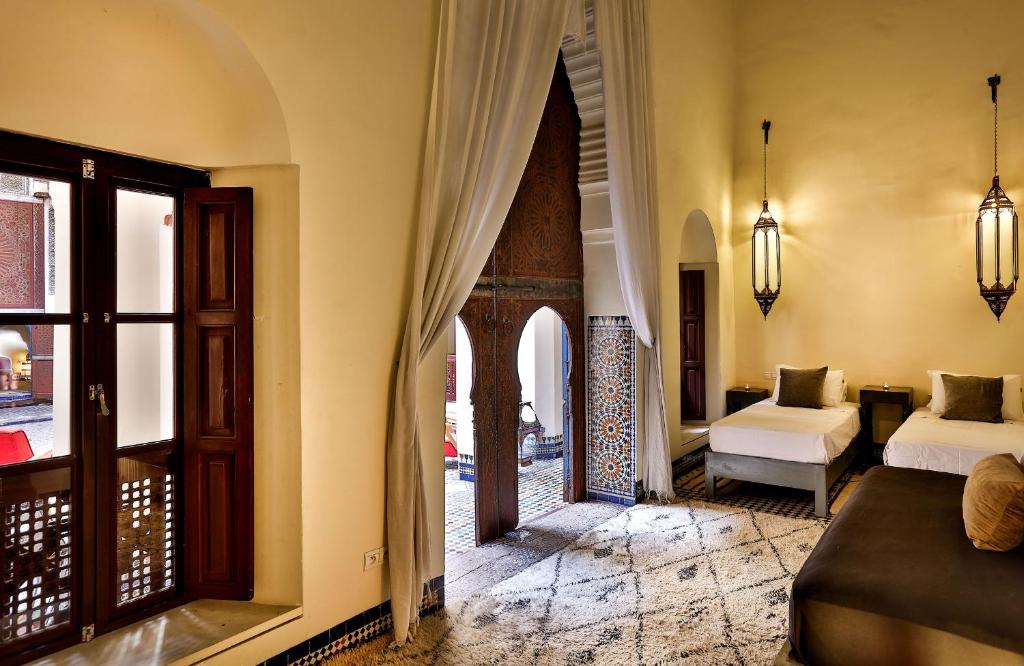 - une chambre avec un lit et une chambre avec une porte dans l'établissement Hotel & Spa Dar Bensouda, à Fès