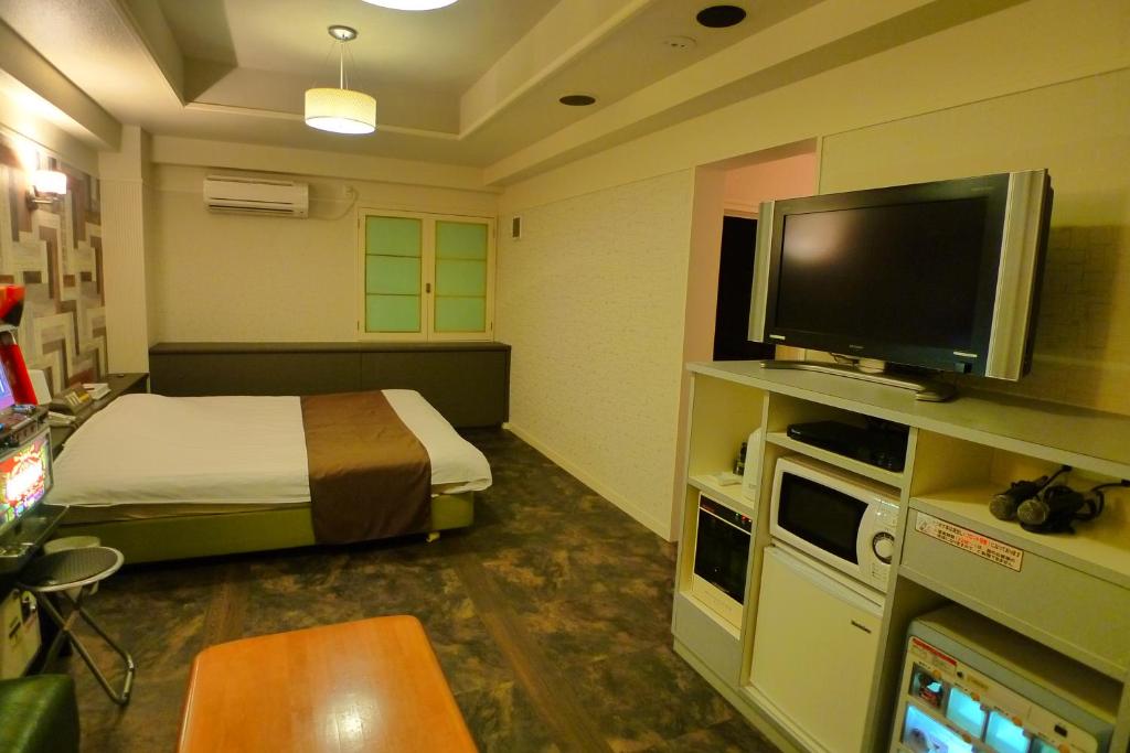 une chambre d'hôtel avec un lit et une télévision à écran plat dans l'établissement Hotel GOLF III Atsugi (Adult Only), à Atsugi