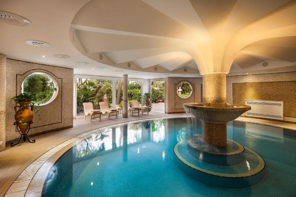 - une grande piscine avec une fontaine dans un bâtiment dans l'établissement Excelsior Belvedere Hotel & Spa, à Ischia