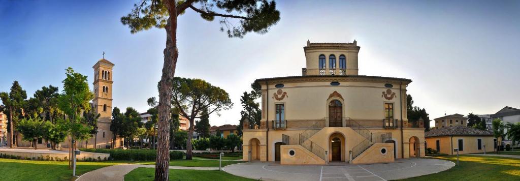 un bâtiment avec une tour d'horloge dans un parc dans l'établissement Hotel Mare Blu -- boutique, à Pineto