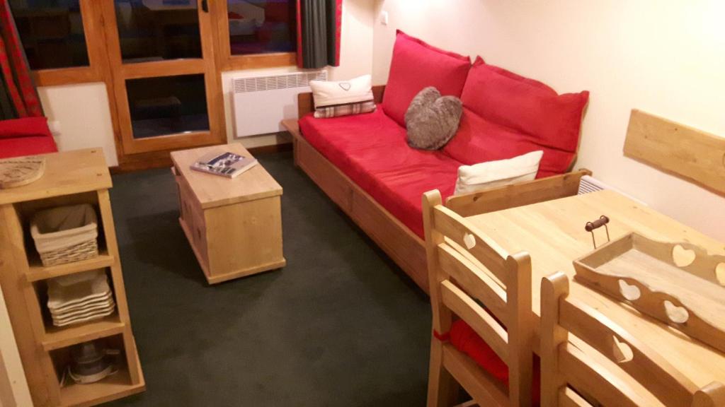 une chambre avec un canapé rouge et un chat assis sur lui dans l'établissement Appartement La Plagne Soleil, à La Plagne