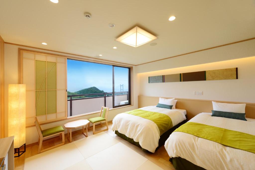 une chambre avec deux lits et une grande fenêtre dans l'établissement Washu Blue Resort風籠 Kasago, à Kurashiki