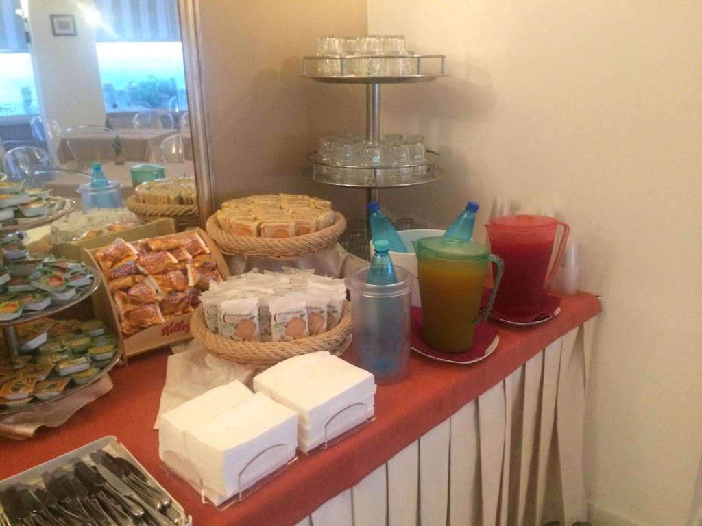 un buffet avec des gâteaux et d'autres aliments sur une table dans l'établissement Hotel Baia Azzurra, à Taormine
